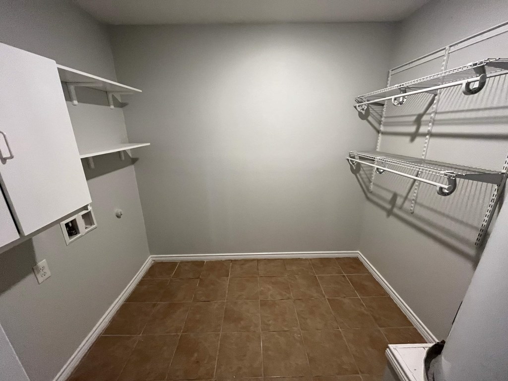 Empty room with white cabinets and shelves.