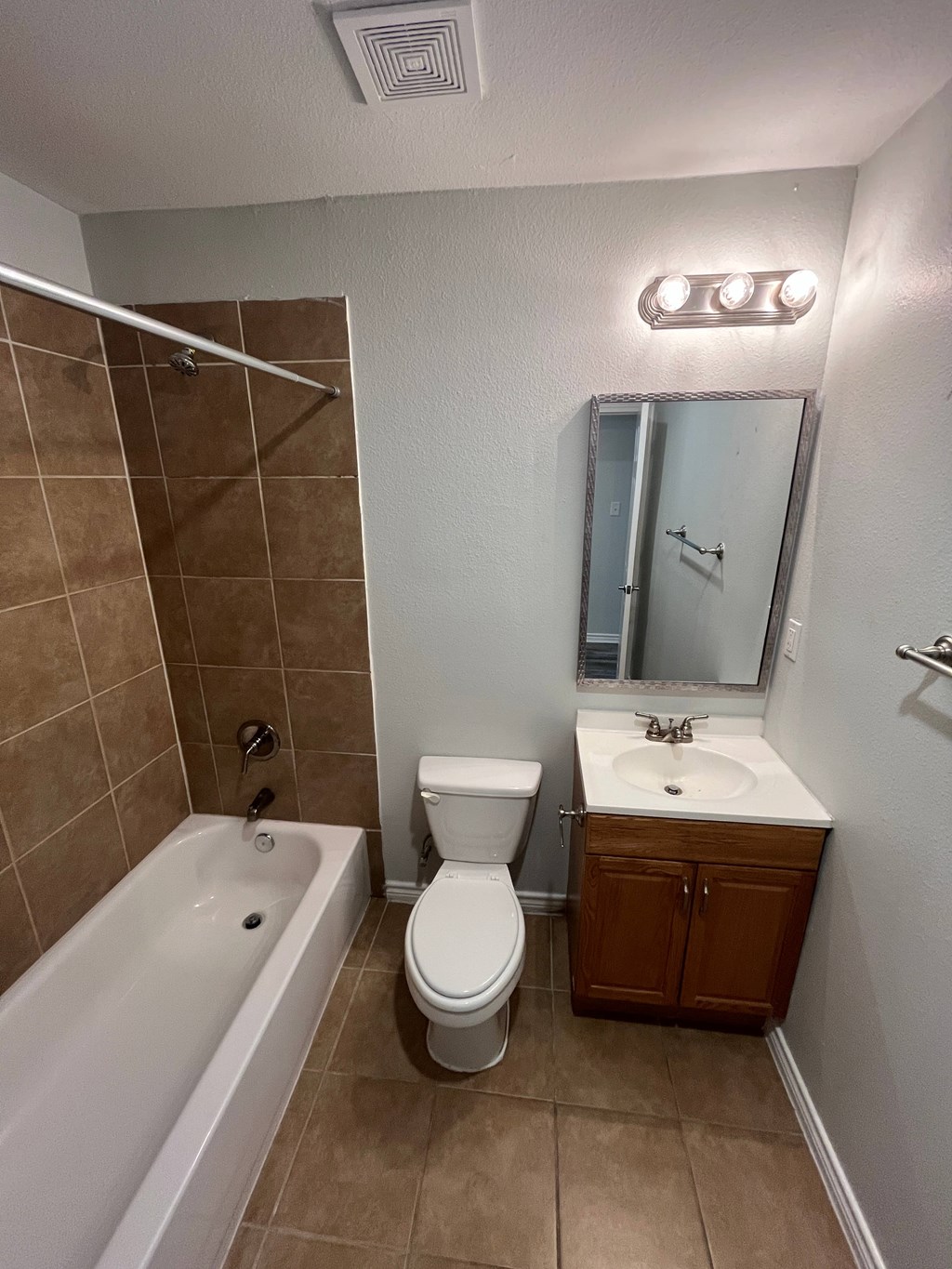 A bathroom with a toilet, sink, and bathtub.