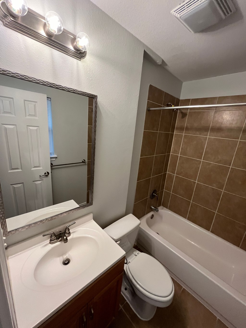 A bathroom with a sink, toilet, and bathtub.