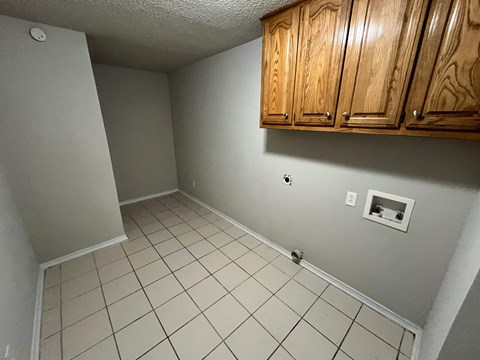 a bathroom with a tiled floor and wooden cabinets
