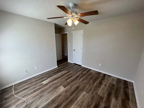 a living room with wood floors and a ceiling fan