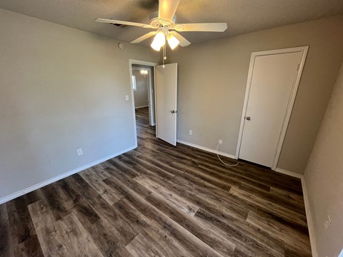 a living room with wood flooring and a ceiling fan
