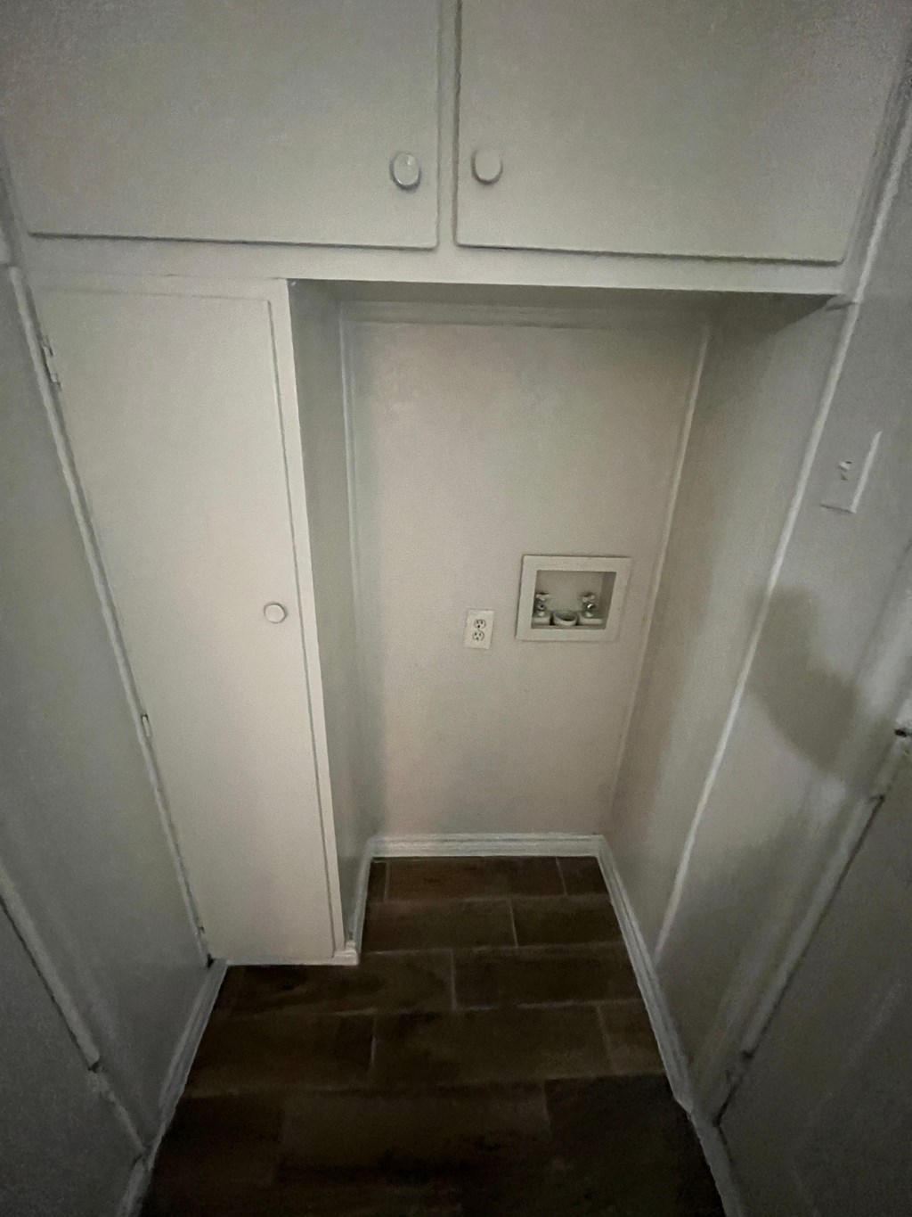 a small hallway with white cabinets and a tile floor