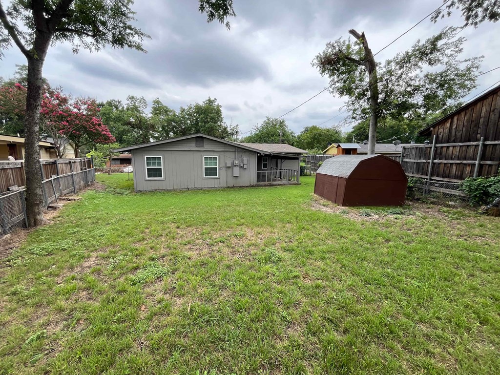 a backyard with a chicken coop and a shed in the yard