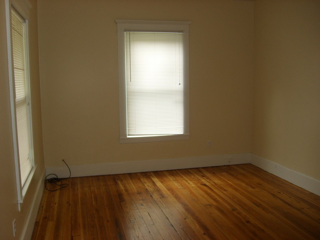 A room with a window and wooden floors.