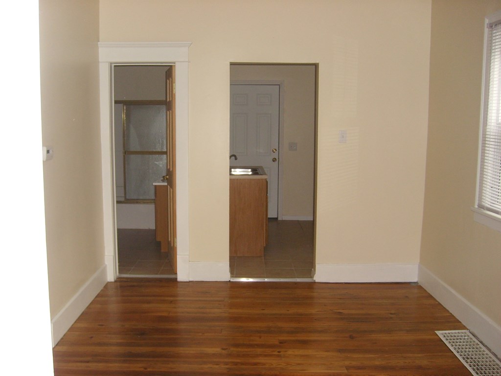 A room with a wooden floor and a white door.