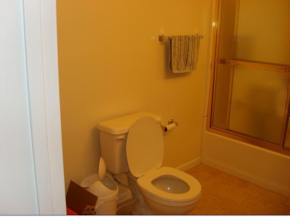 A toilet in a bathroom with a towel rack above it.