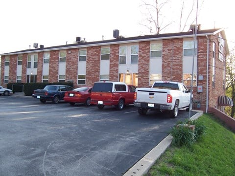 a large brick building with cars parked in front