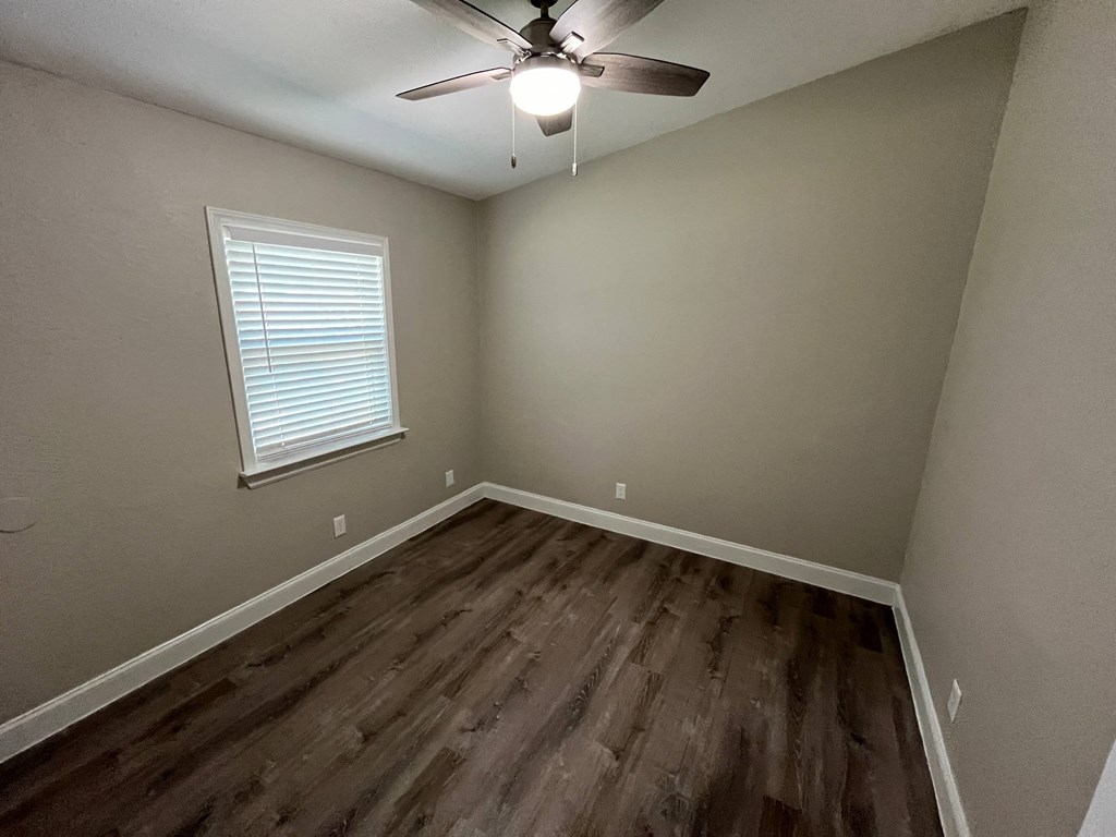 a bedroom with hardwood flooring and a ceiling fan
