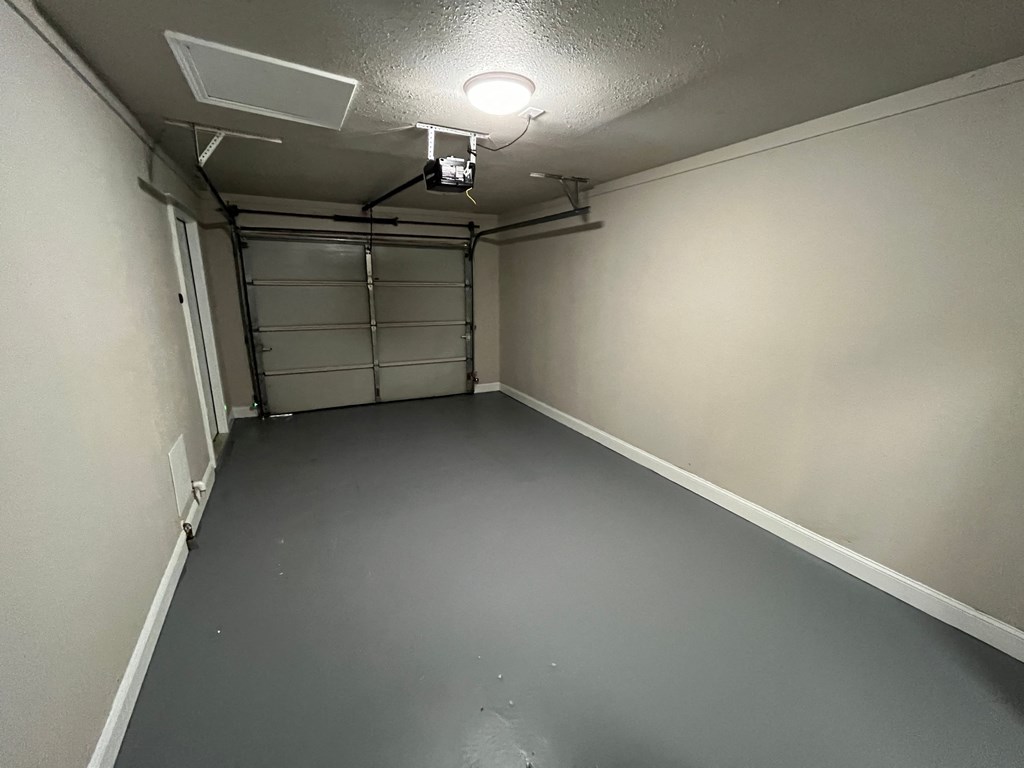 a empty room with a garage door and a light on the ceiling