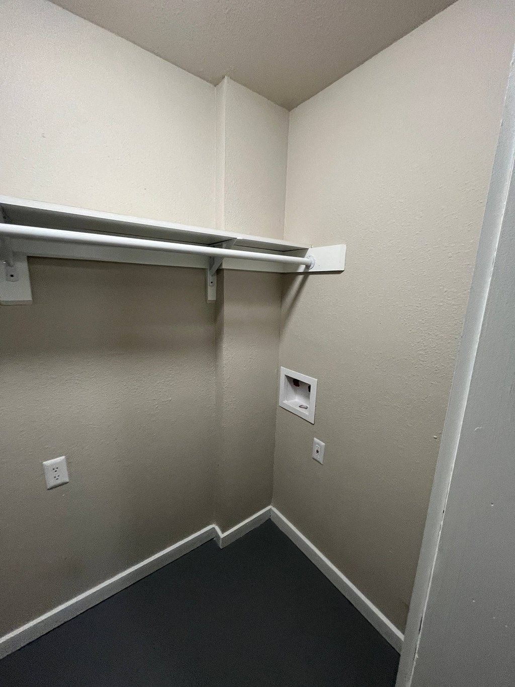 a small closet in a room with a hanging bar on the wall