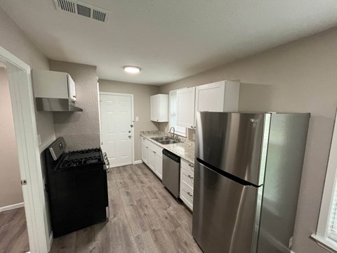 A kitchen with a black fridge and stove.
