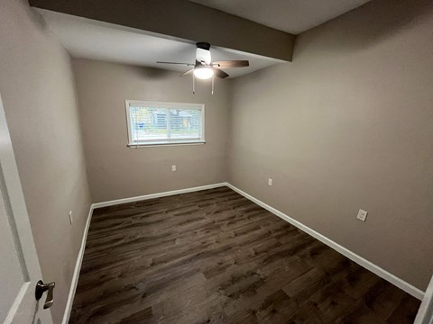 A room with a window and a ceiling fan.