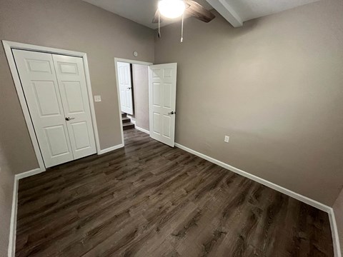 A room with a white door and a wooden floor.
