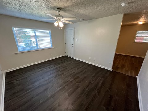 A room with a ceiling fan and a window with blinds.