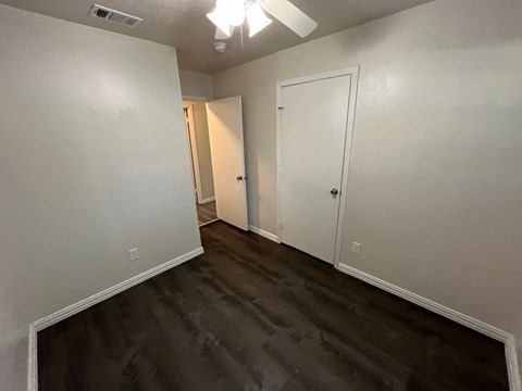 A room with two doors and a ceiling fan.