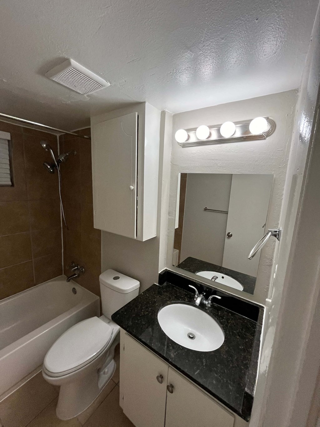 a bathroom with a sink toilet and tub and a mirror