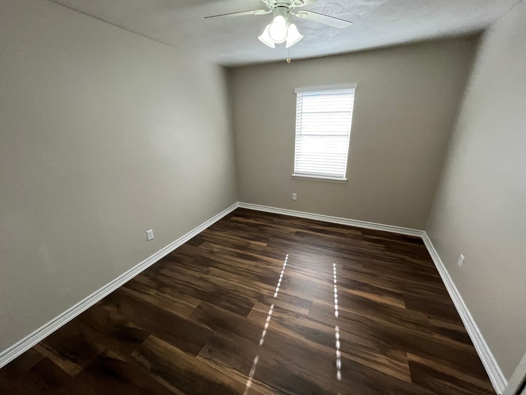 a room with wooden floors and a ceiling fan