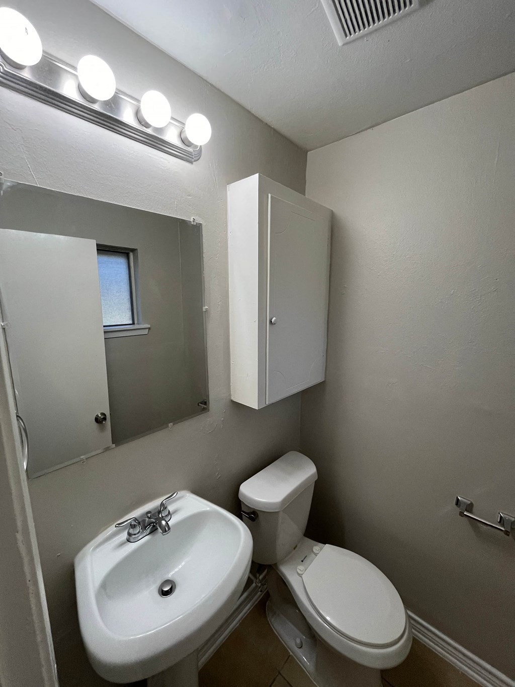 a small bathroom with a sink toilet and mirror