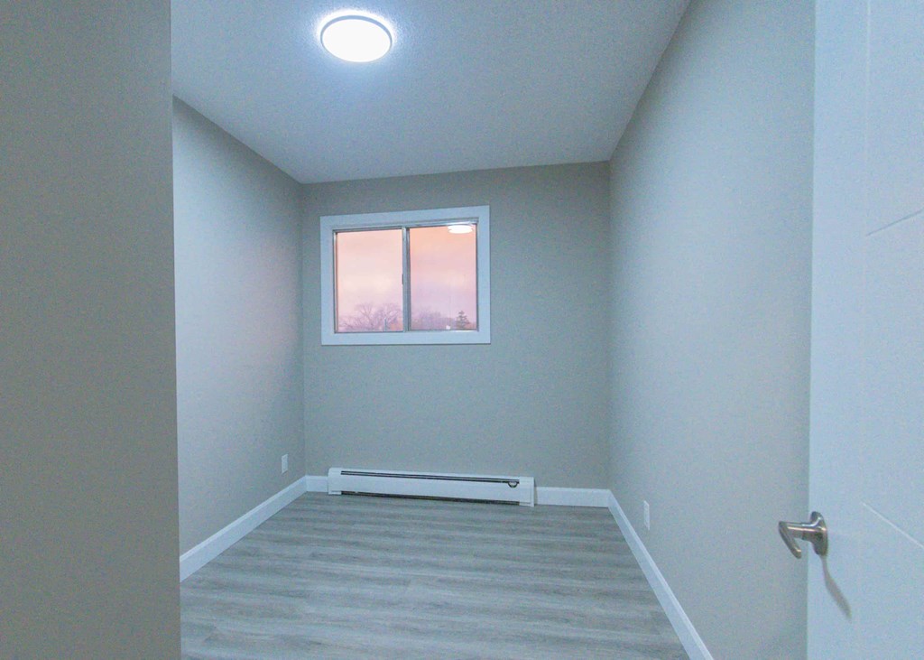 an empty room with a window and stairs