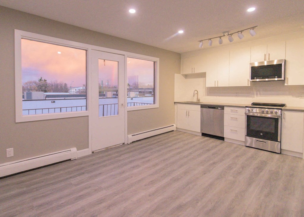 a kitchen with a stove and a sink and a window