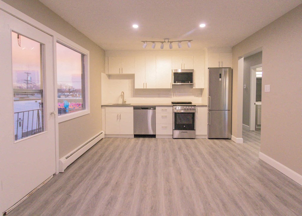 a brand new kitchen with stainless steel appliances and white cabinets