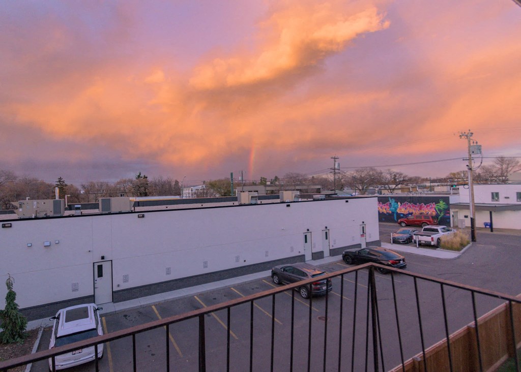 the view of a parking lot from a balcony at sunset