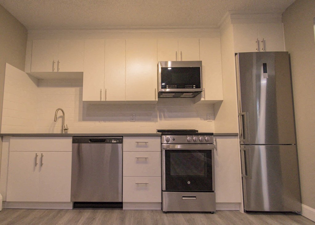 a kitchen with stainless steel appliances and white cabinets