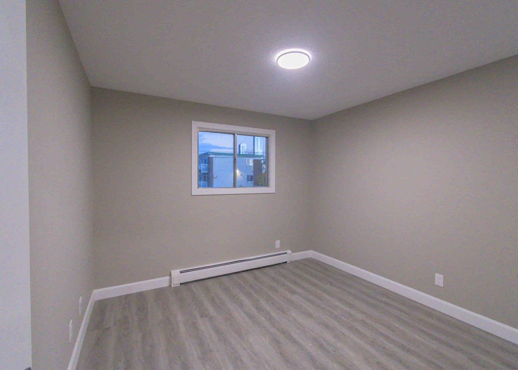 an empty room with white walls and a window