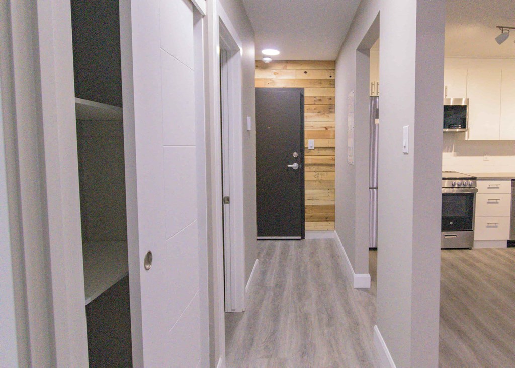 a pass through closet in a renovated kitchen with wood floors