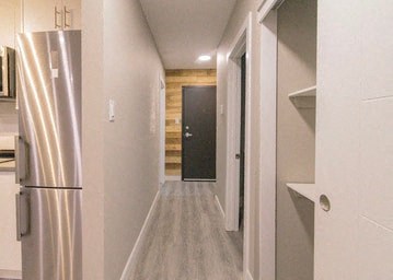 a hallway with a refrigerator and a door