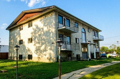 a white house with a balcony and a sidewalk