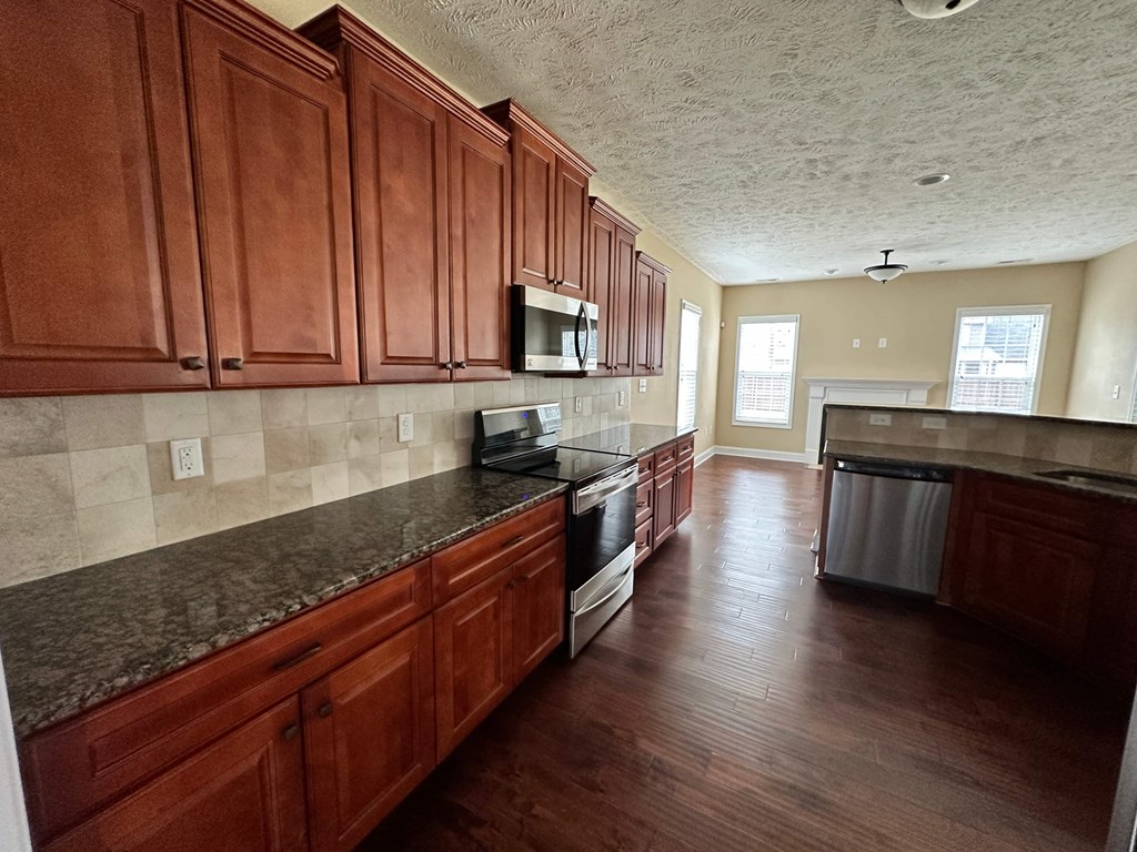 a kitchen with wooden cabinets and a stove and a microwave