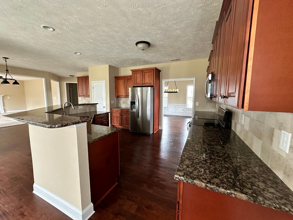 a kitchen with granite counter tops and wooden cabinets