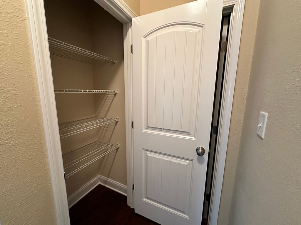 a walk in closet with shelves and a white door