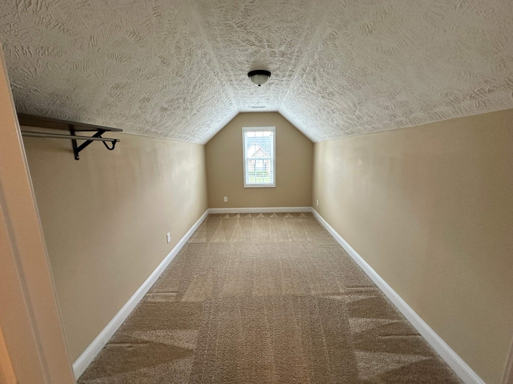 a empty room with a carpeted floor and a window