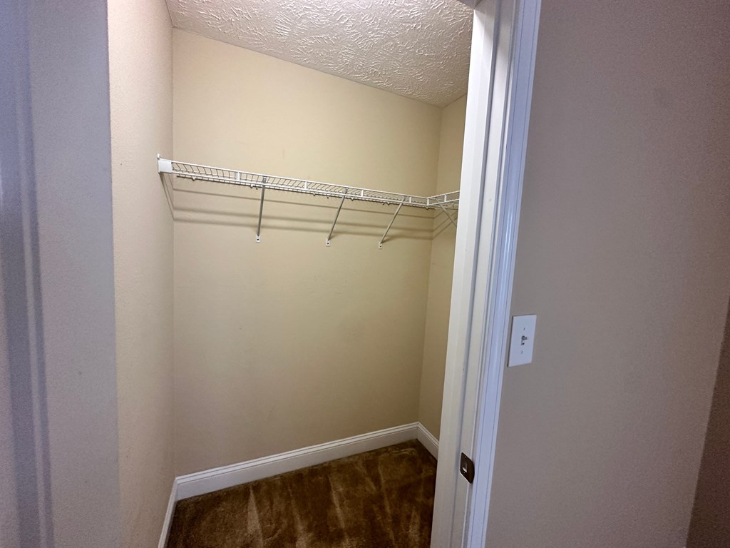 a walk in closet with a hanging rack