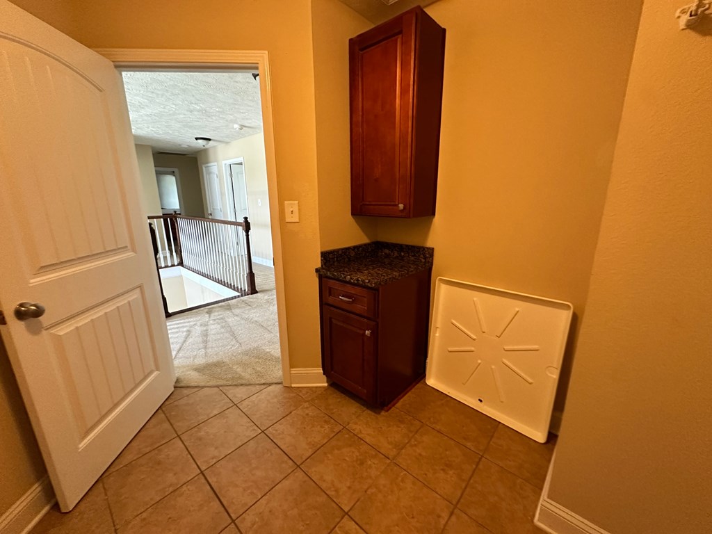 a kitchen with a door to a hallway with a cabinet and a sink