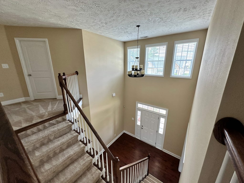 the landing of a staircase in a house with a door and a window