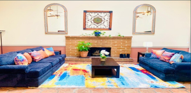a living room with two blue couches and a fireplace