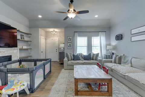 a living room with couches and a table and a ceiling fan