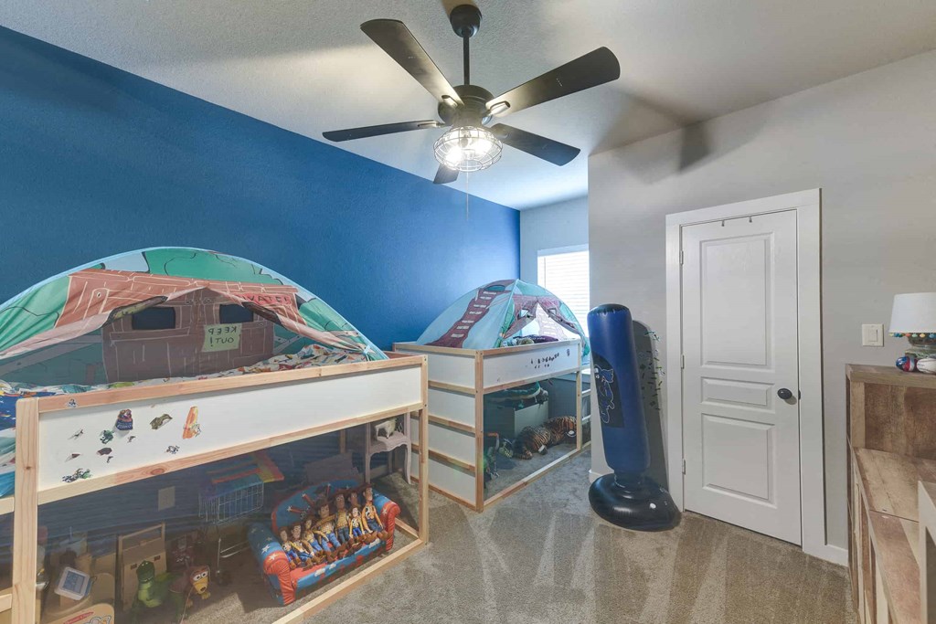 a bedroom with two bunk beds and a ceiling fan