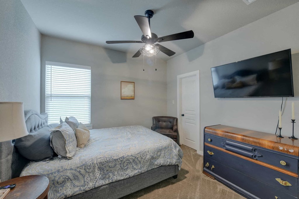 a bedroom with a bed and a ceiling fan