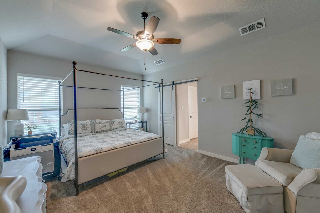 a bedroom with a bed and a ceiling fan