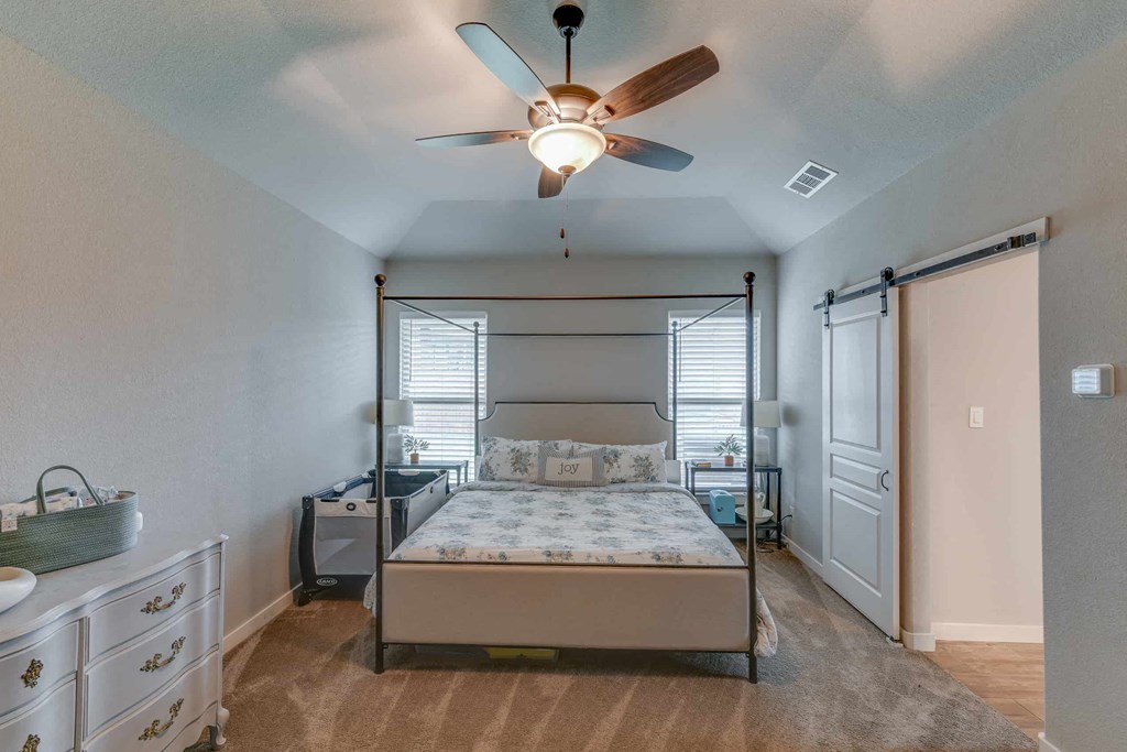 a bedroom with a bed and a ceiling fan