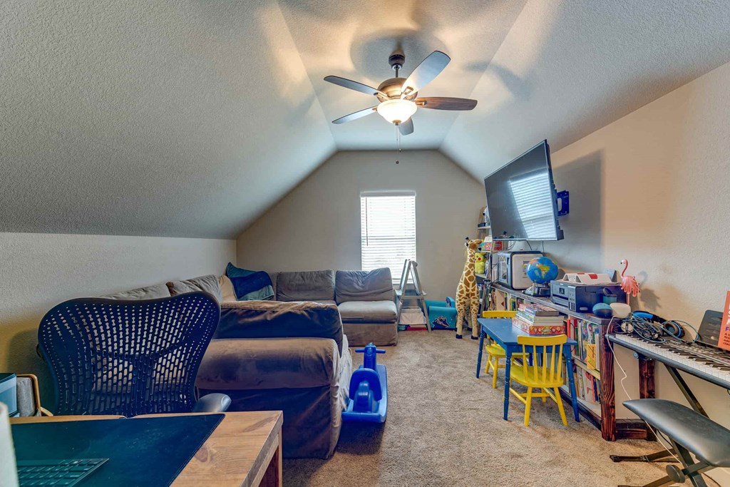 spacious living room with vaulted ceilings and a ceiling fan