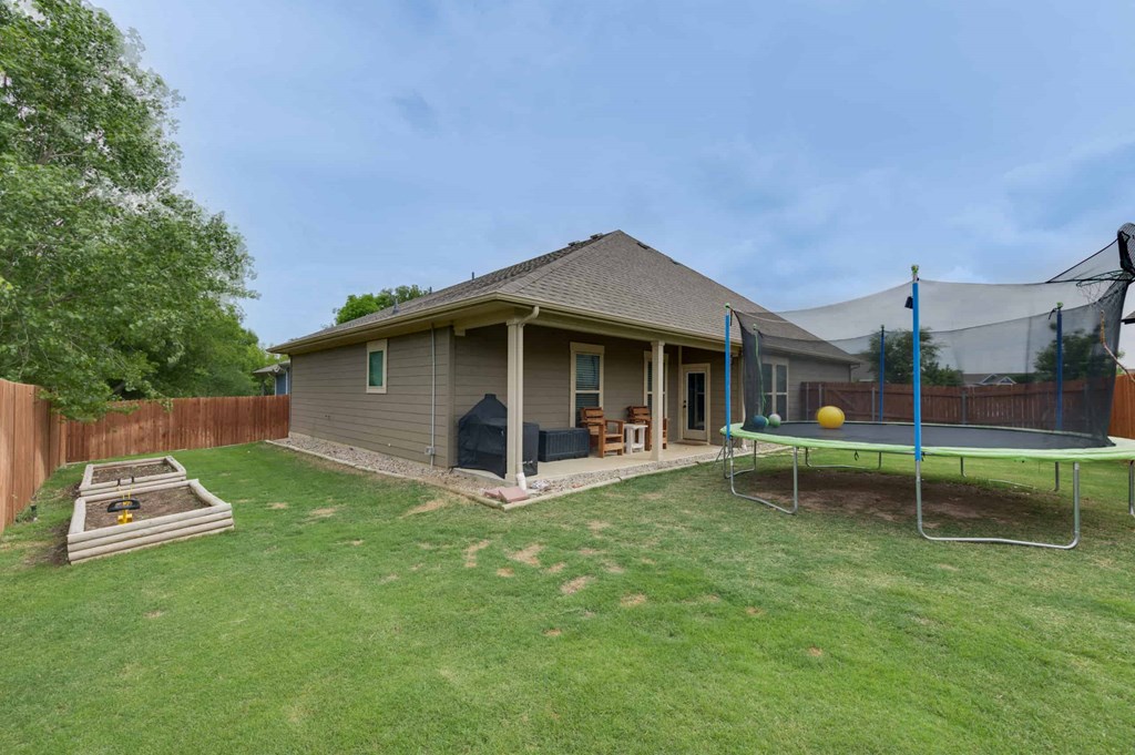 a backyard with a trampoline and a house