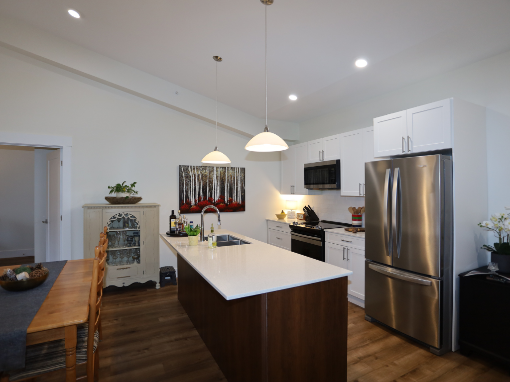 a kitchen with a large island and a stainless steel refrigerator