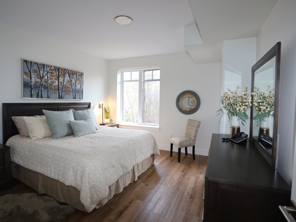 a bedroom with a bed and a dresser and a window