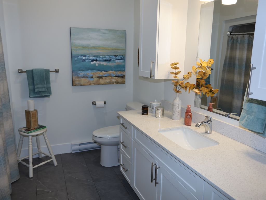 a bathroom with a toilet and a sink and a painting on the wall